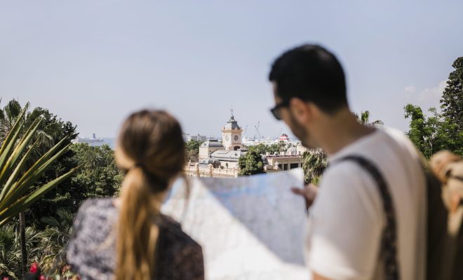vista-trasera-turista-mirando-mapa-explorando-ciudad